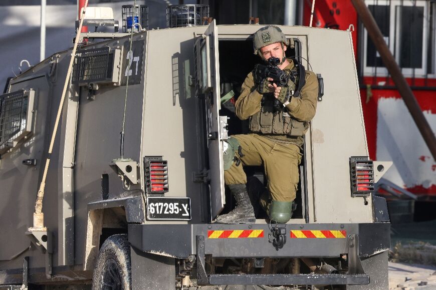 An Israeli soldier aims his rifle during a raid on the Nur Shams refugee camp in the occupied West Bank