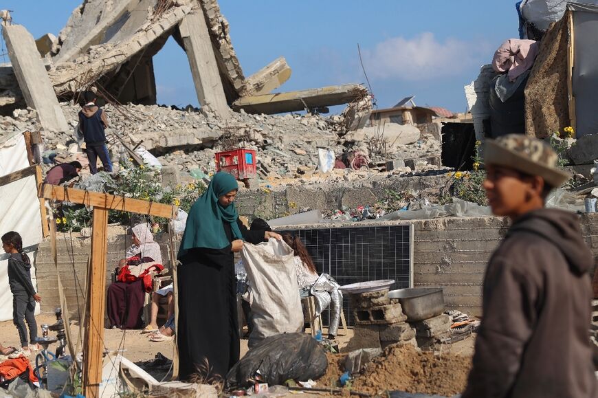 Displaced Palestinians pack their belongings before leaving an unsafe area in Rafah on May 15, 2024