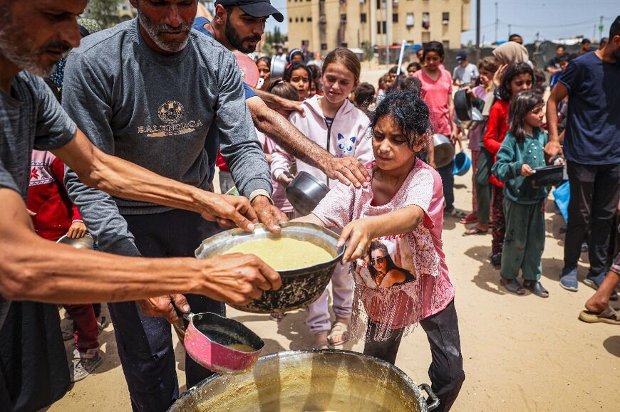 Displaced Palestinian children line up to receive food in southern Gaza's Rafah