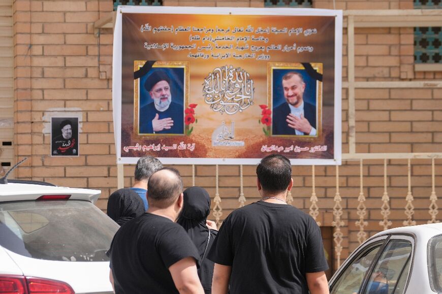 Portraits of Iran's President Ebrahim Raisi, on the left, and Foreign Minister Hossein Amir-Abdollahian on a wall in the central Iraqi holy city of Najaf