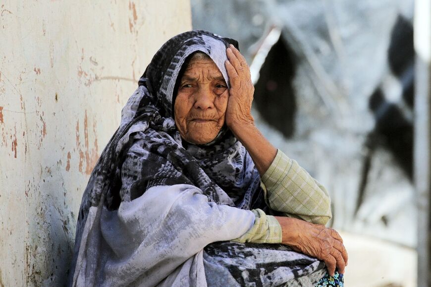 An elderly Palestinian woman sits in a street in Deir el-Balah in the central Gaza Strip on May 15, 2024 