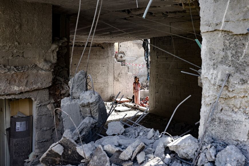 A Palestinian child stares at the rubble of a building hit by an overnight Israeli strike in the occupied West Bank's Jenin refugee camp