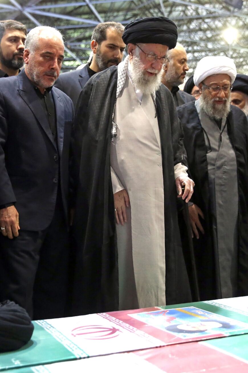 Flanked by top officials, Iran's supreme leader Ayatollah Ali Khamenei says prayers over the coffins of president Ebrahim Raisi and his entourage