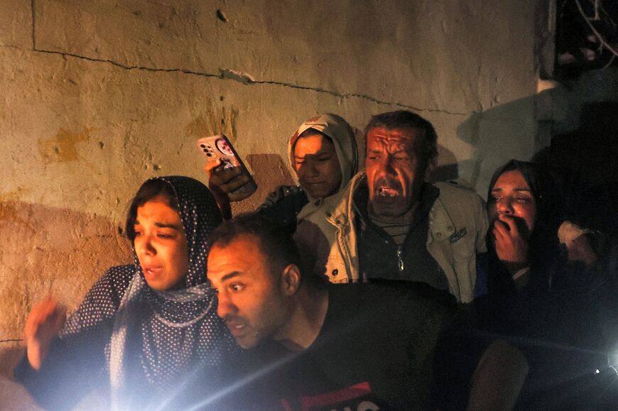 Family members gather around a wounded relative as civil defence teams help rescue victims from a home struck by Israeli bombardment in Rafah