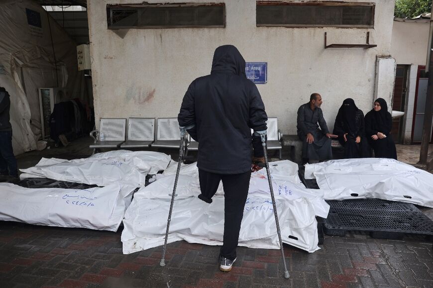 Palestinians mourn by bodies of relatives killed following Israeli strikes on Rafah in the southern Gaza Strip