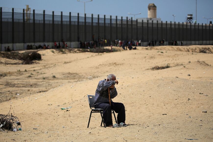 A man sits in a camp for Palestinian displaced people in Rafah in the southern Gaza Strip by the border with Egypt