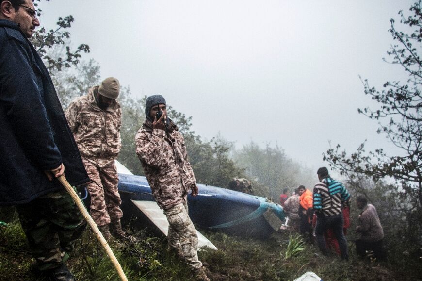 Rescue team members work at the crash site of Raisi's helicopter