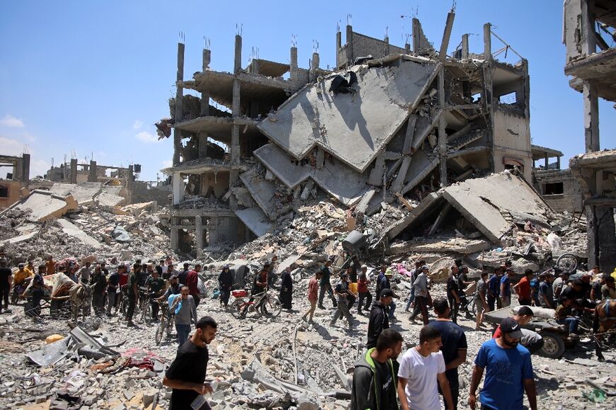 Palestinians carry some salvaged belongings as they leave the Jabalia refugee camp