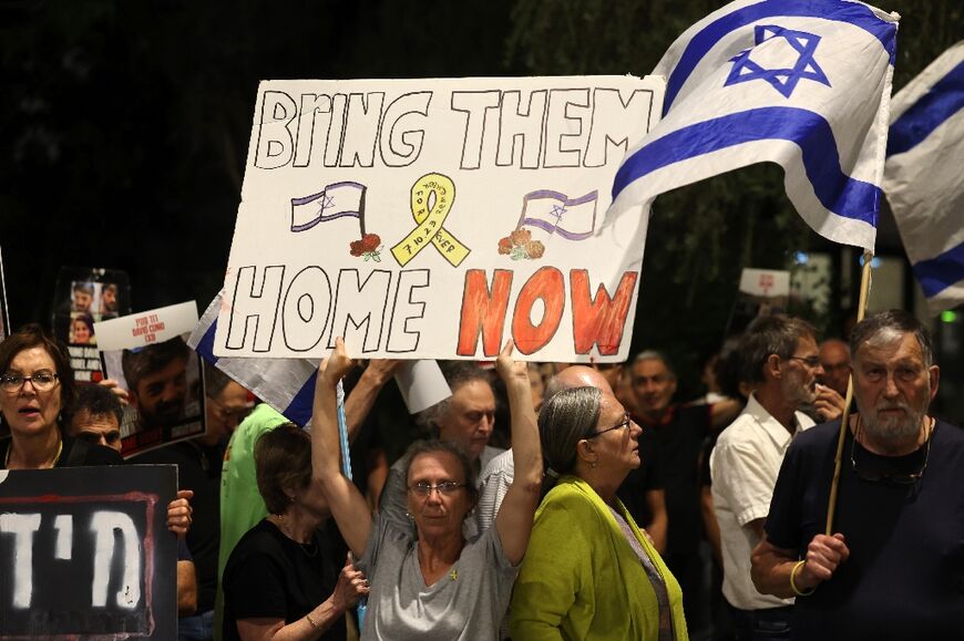 Relatives and supporters raise placards with messages and portraits of Israeli hostages held in Gaza since the October 7 attacks in a rally outside the PM's office in Jerusalem on May 22, 2024