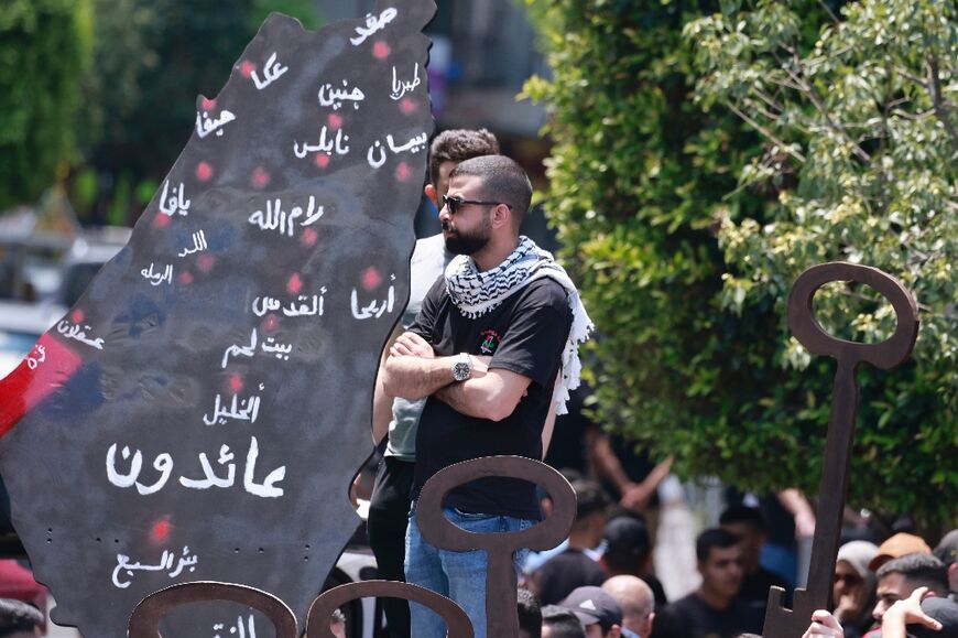 Palestinian protesters hold symbolic keys during a rally in Ramallah to mark the 76th anniversary of the "catastrophe" of the creation of Israel