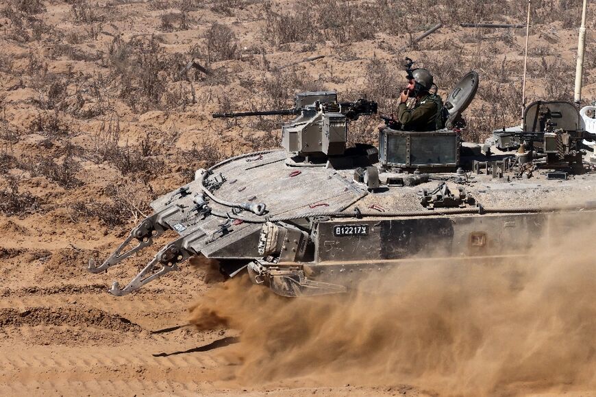 Israeli soldiers man an armoured vehicle operating near the border with the Gaza Strip