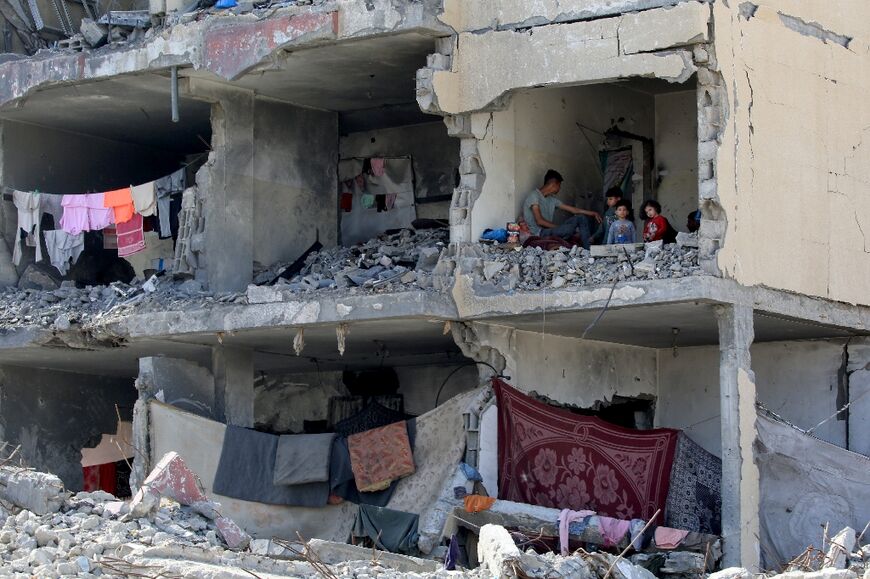 A Palestinian man and his children inside a building that was hit by an Israeli airstrike in Rafah in the southern Gaza Strip 