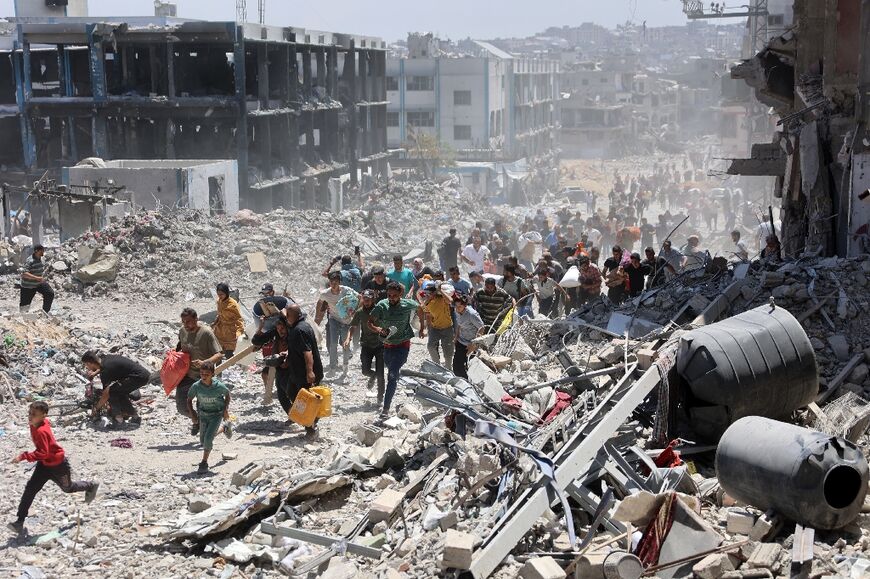 Palestinians who returned briefly to the Jabalia refugee camp in northern Gaza to check on their homes run for cover after an Israeli strike on May 30, 2024