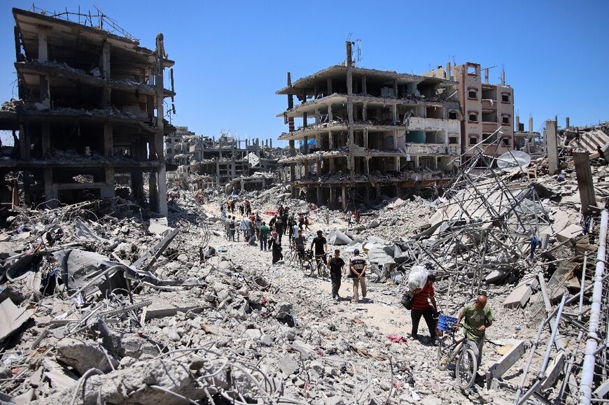 Gazans returning to Jabalia walk through the rubble-strewn streets, now full of grey concrete slabs