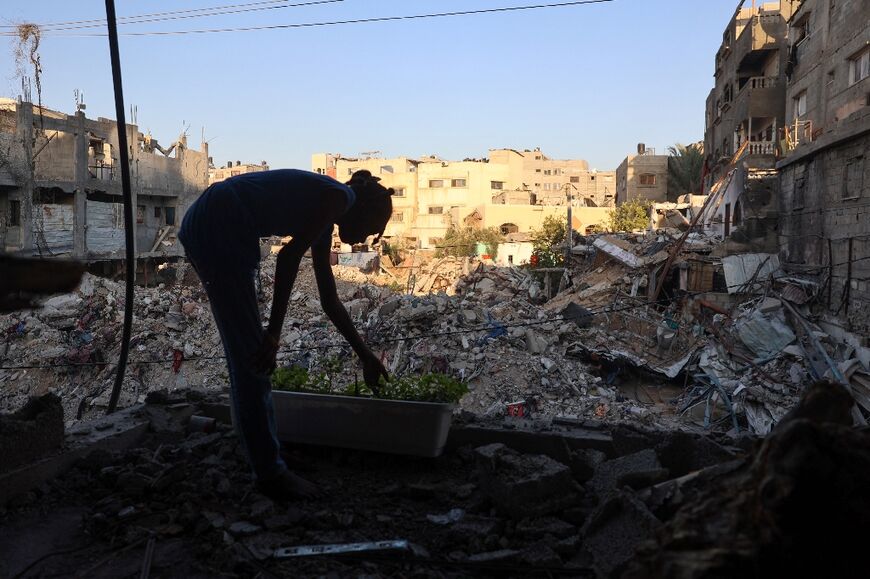 A displaced Palestinian girl stands inside a damaged building in which she took refuge in Bureij refugee camp