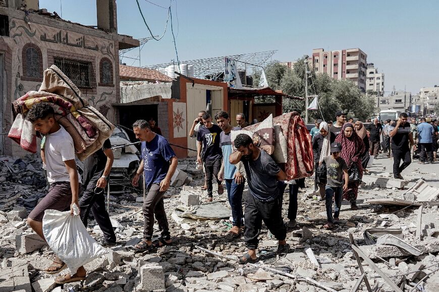 Palestinians evacuate with their belongings from the area of Nuseirat devastated by the Israeli special forces operation