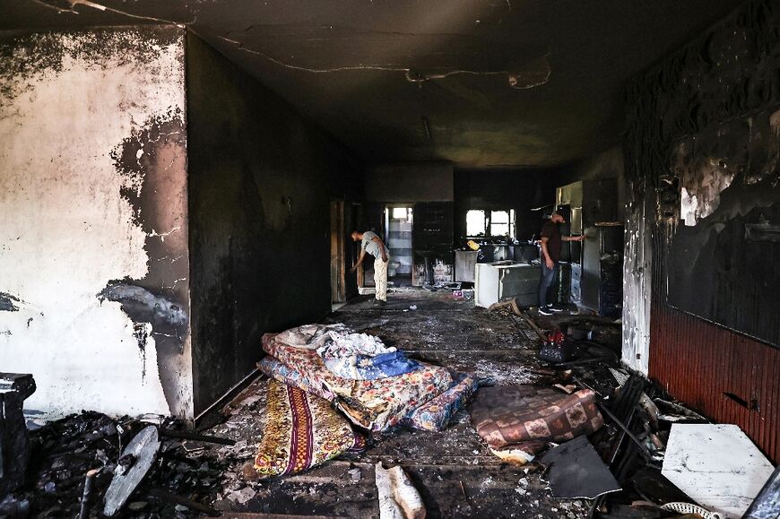 Palestinian villagers inspect the damage after Israeli settlers rampaged through the West Bank village of Duma in April, torching homes and vehicles