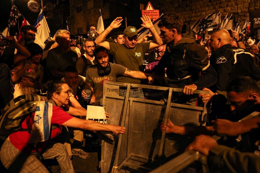 Israeli protestors try to tear down a police barricade near the prime minister's residence during an anti-government rally in Jerusalem