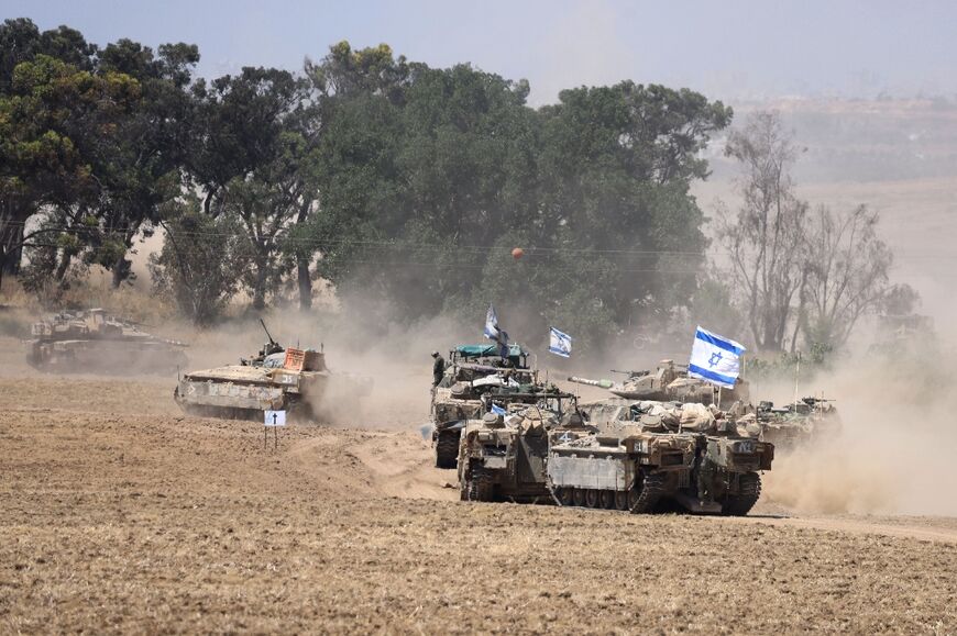 Israeli army vehicles drive near Israel's southern border with the Gaza Strip amid the ongoing conflict with the Palestinian militant group Hamas