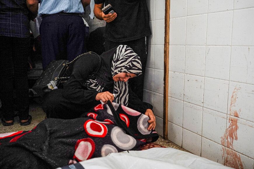 A woman mourns over the body of a relative at Al-Aqsa Martyrs Hospital in Deir al-Balah