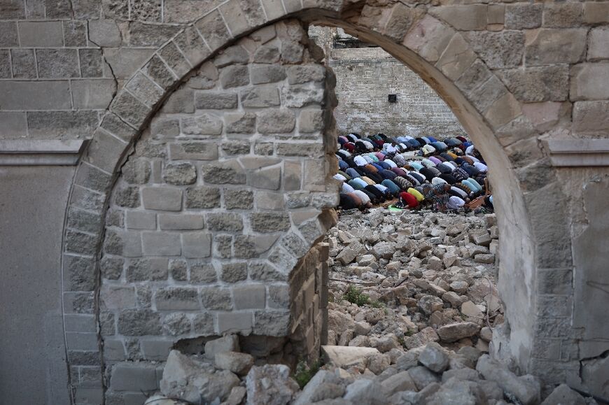 Palestinians perform the Eid al-Adha morning prayer in the courtyard of Gaza City's historic Omari Mosque that was heavily damaged in Israeli bombardment