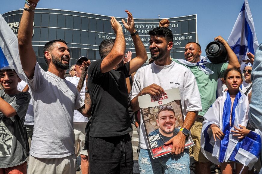 A man holds a picture of Almog Meir Jan, one of four Israeli hostages rescued from captivity in the Gaza Strip on Saturday