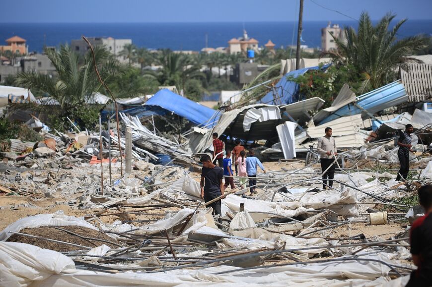 People search through the rubble following an Israeli raid in southern Gaza's Al-Mawasi area