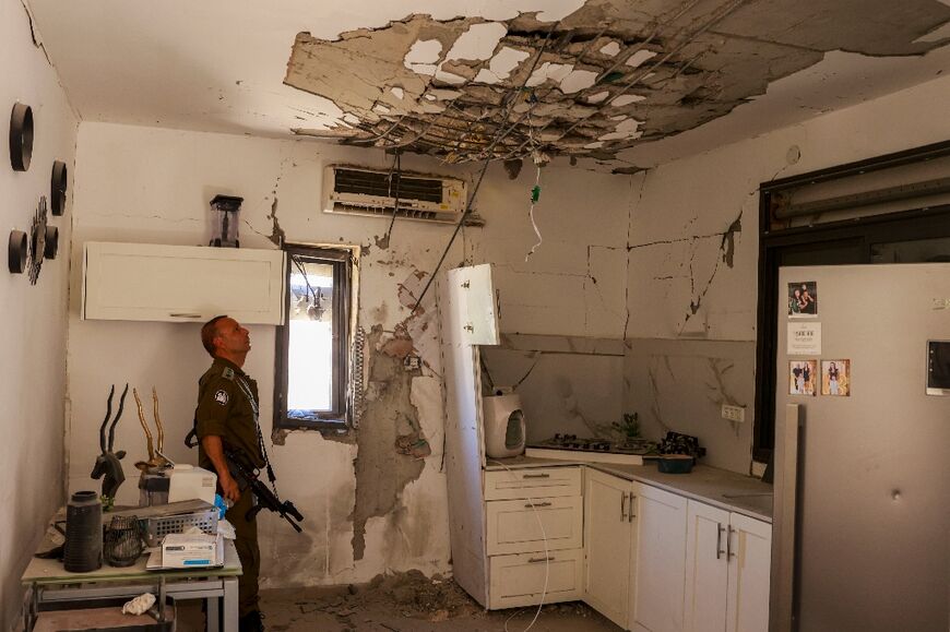 An Israeli soldier checks a house that was hit by a Hezbollah rocket in Kiryat Shmona in northern Israel near the Lebanon border, on June 16, 2024