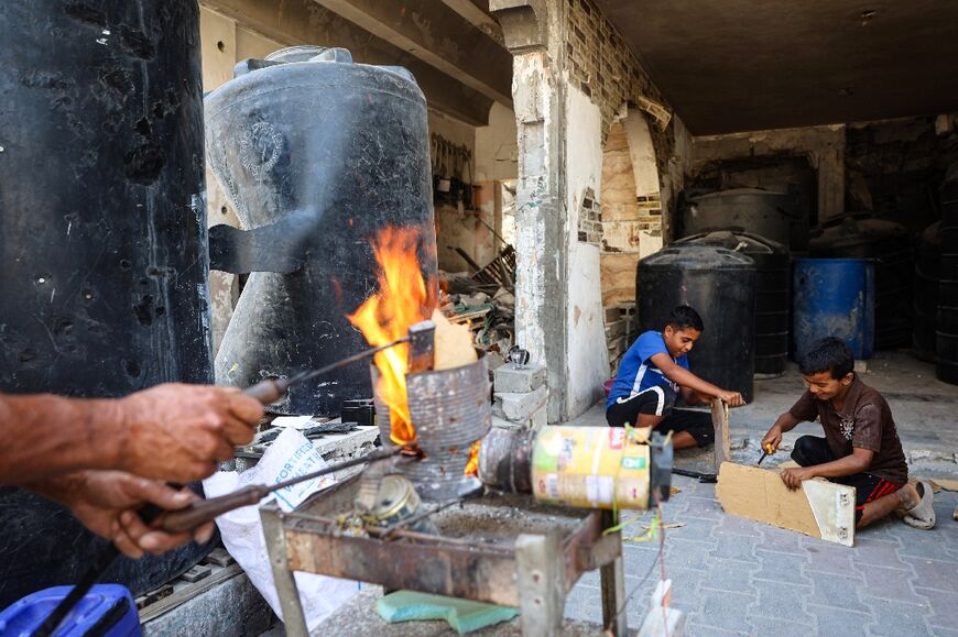 People repair water tanks damaged during Israeli bombardment 