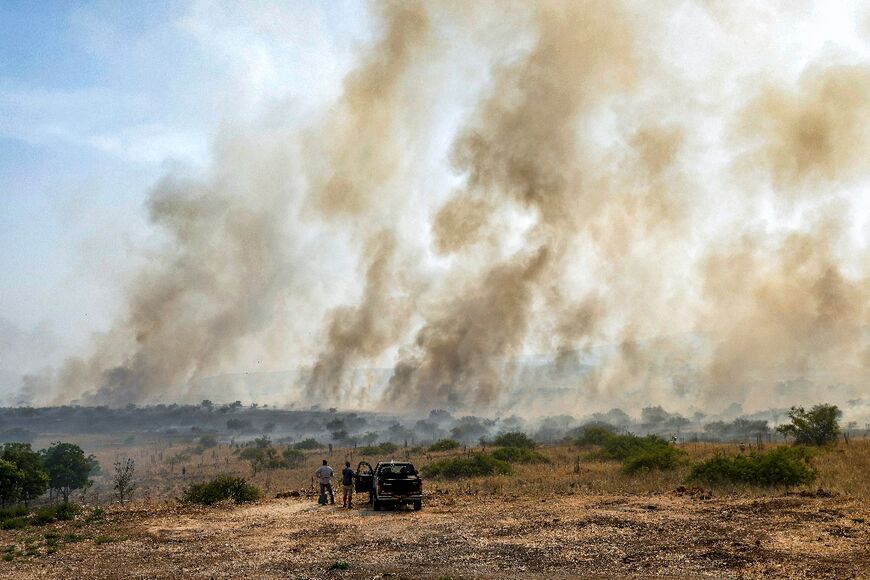 Onlookers watch smoke from burning fields after rockets fired from south Lebanon hit near Katzrin in the Israel-annexed Golan Heights