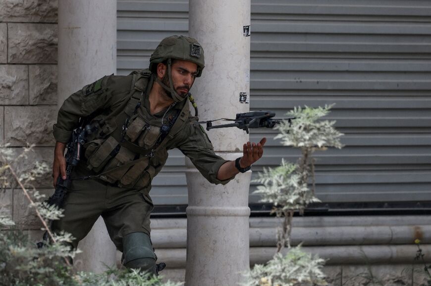 An Israeli soldier flies a small drone in the Nur Shams refugee camp in the occupied West Bank, during a raid on April 19, 2024