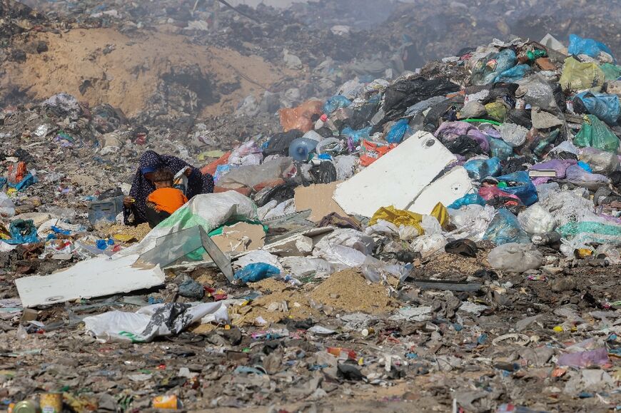 Palestinians search for salvageable items in a garbage dump in what used to be Gaza City's Firas market