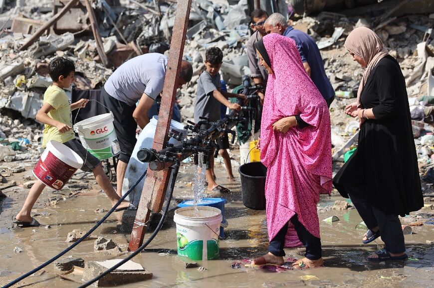 Palestinians fill water from a standpipe erected in Jabalia refugee camp, northern Gaza