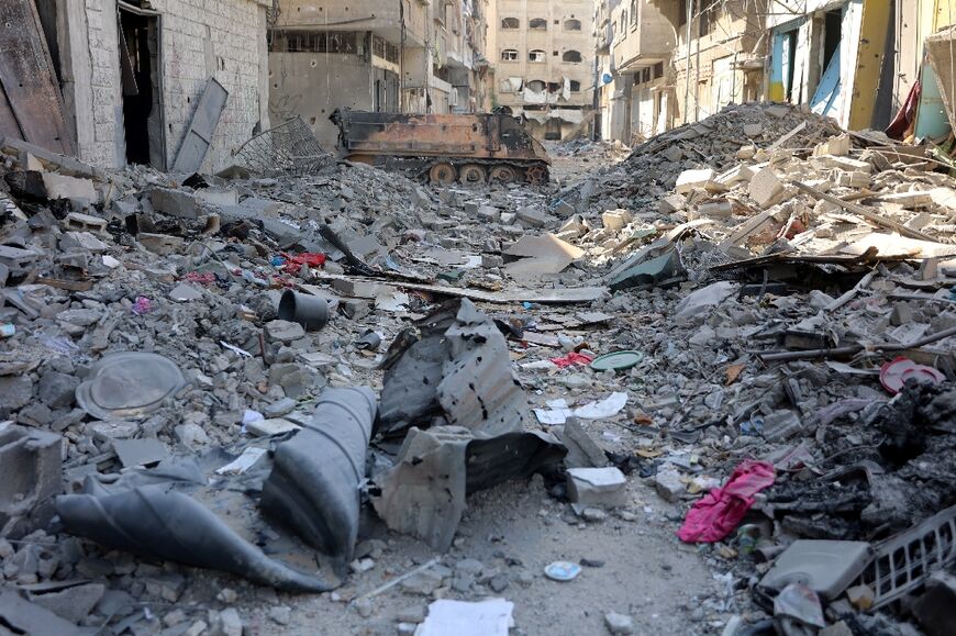 A burnt out Israeli armoured vehicle is seen amid the rubble littering the streets of Shujaiya after Israeli troops pulled out of the neighbourhood