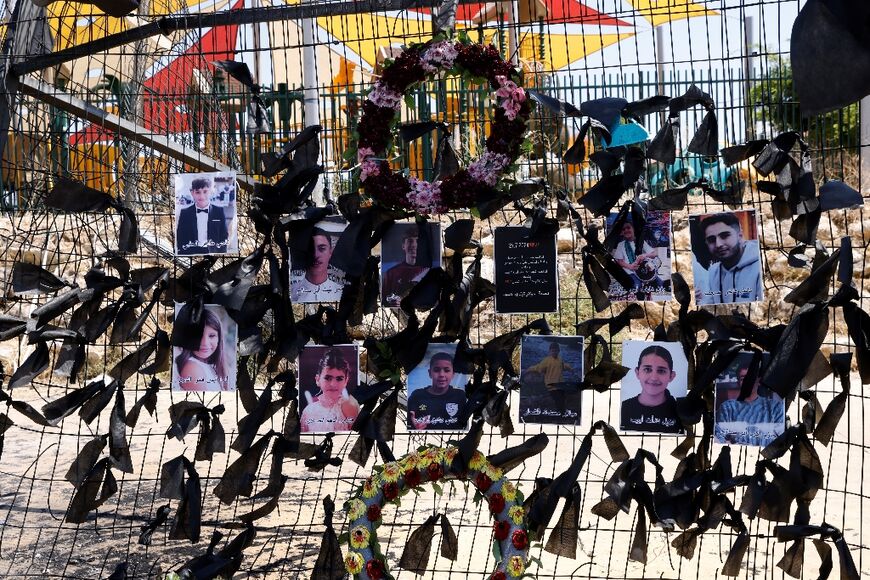 Portraits of the children and teens hang on the football stadium fence where a rocket landed and killed them, in the Druze Arab village of Majdal Shams, in the Israel annexed Golan Heights