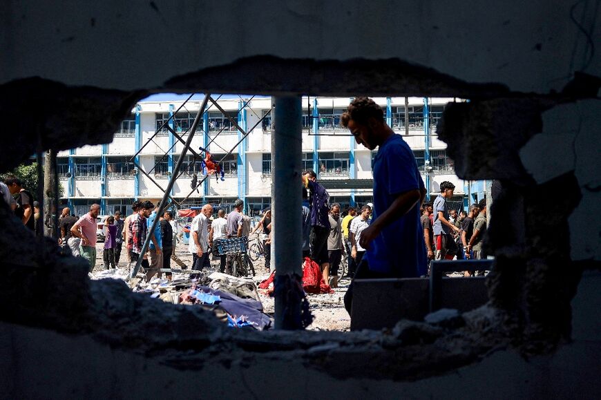 Palestinians check the destruction at the UN-run Al-Razi School in the Nuseirat refugee camp after an Israeli strike