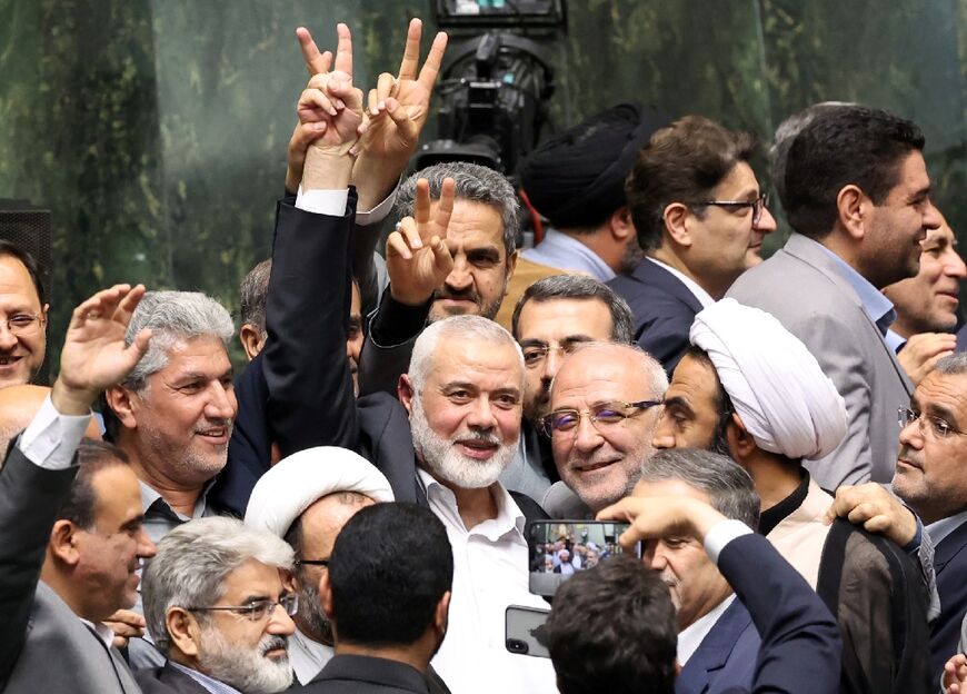 Hamas political leader Ismail Haniyeh flashes a victory sign during the swearing-in of Iranian President Masoud Pezeshkian hours before his death in an air strike in Tehran