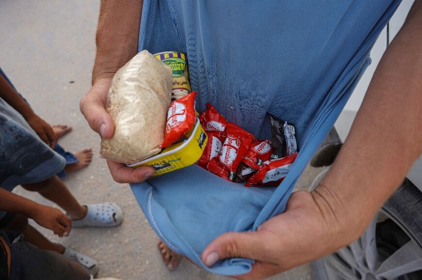 A Palestinian shows food collected from aid parcels airdropped in the Khan Yunis area, southern Gaza -- a UN-backed assessment said almost 500,000 people in Gaza are experiencing 'catastrophic' hunger