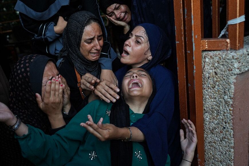 Palestinian women cry as killed members of the Abu Taha family are brought for burial, outside Nasser hospital in Khan Yunis following Israeli bombardment east of the city in the southern Gaza Strip