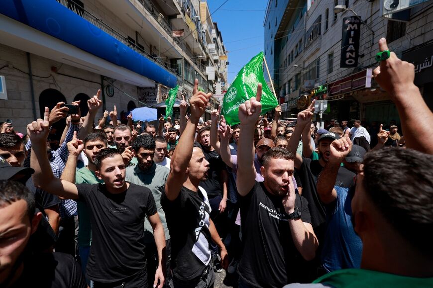 Palestinians wave green Hamas flags at a protest in the city of Ramallah in the Israeli-occupied West Bank against the killing of the militant group's leader Ismail Haniyeh