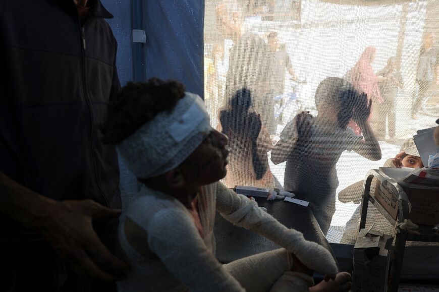 A child peers into a treatment area at Al-Awda Hospital in Nuseirat refugee camp after Israeli bombardment