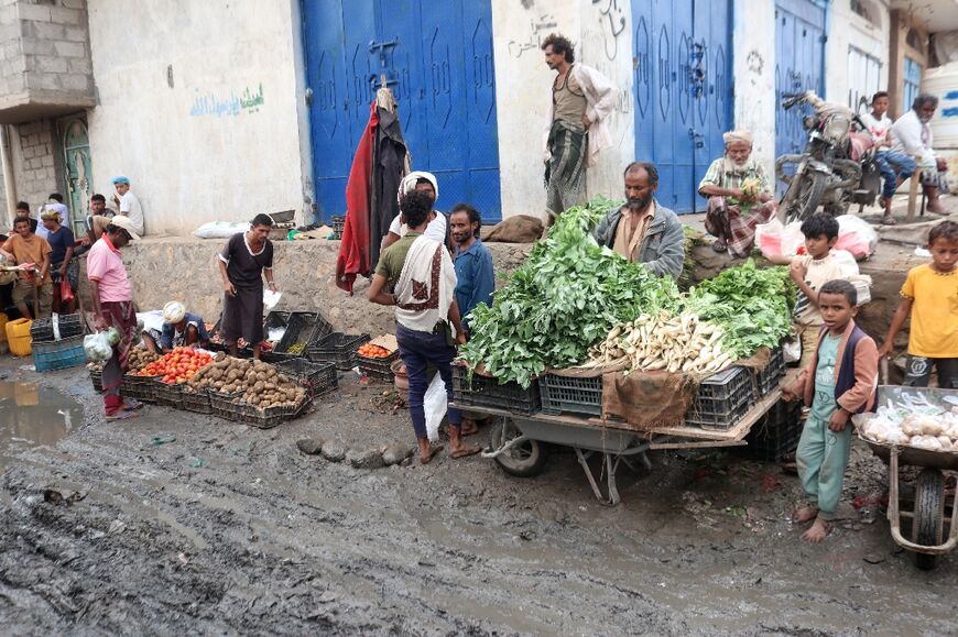 Vendors in Hais sell vegetables by the side of roads reduced to mud by the torrential rains