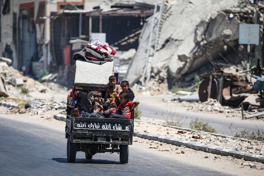 Children sit in the back of a small vehicle as their family flees fighting in the central Gaza town of Deir el-Balah