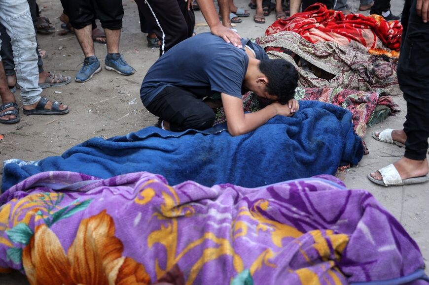 A young man mourns over the corpse of a person killed in the strike on Al-Tabieen religious school