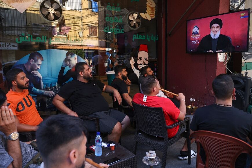 Lebanese men in southern Beirut watch a televised address by Hezbollah chief Hassan Nasrallah, who appeared to suggest the movement's retaliation against Israel may be over