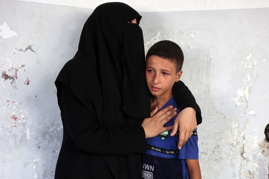 Palestinians mourn a relative at a hospital in Gaza City following an Israeli strike on a school sheltering people displaced by the war