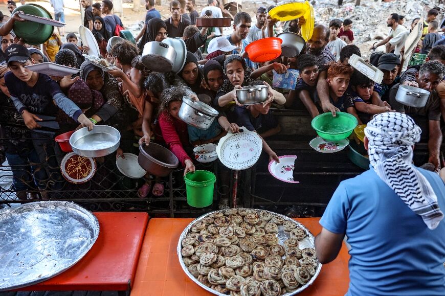 With food shortages widespread in Gaza, Palestinians wait for vegetable patties prepared by volunteers in Beit Lahia, northern Gaza 