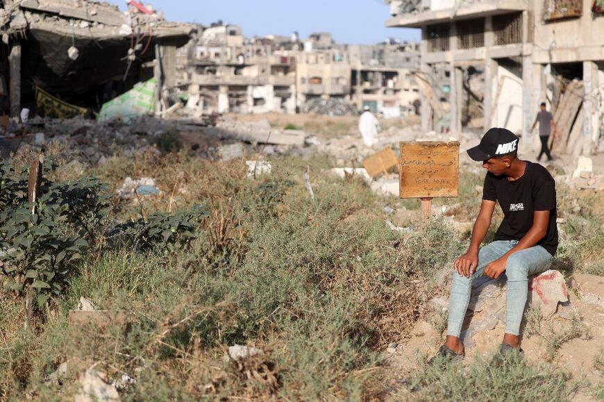 A Palestinian visitng the grave of a relative at a makeshift cemetery in Gaza City