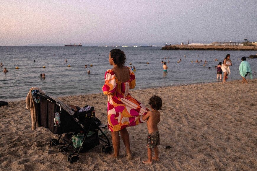 People on the shores of the Mediterranean Sea in Israel's northern coastal city of Haifa, as diplomats try to avert a region-wide war