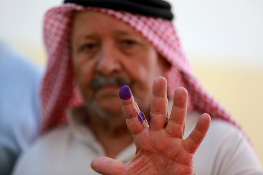 A man displays his ink-stained finger after voting